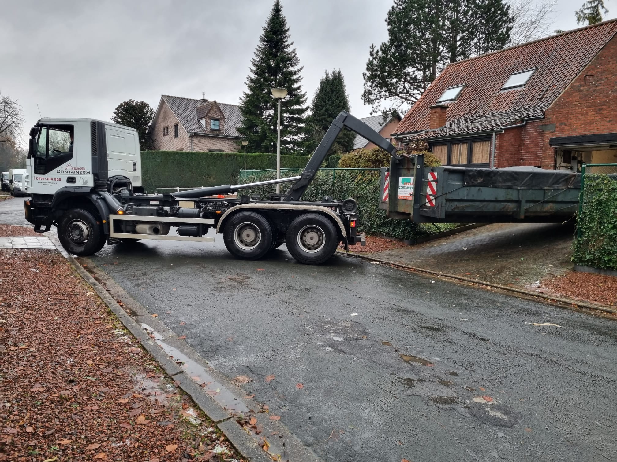 Un gros camion est garé dans une rue devant une maison.